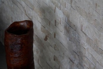Textured tile surround a fireplace.
